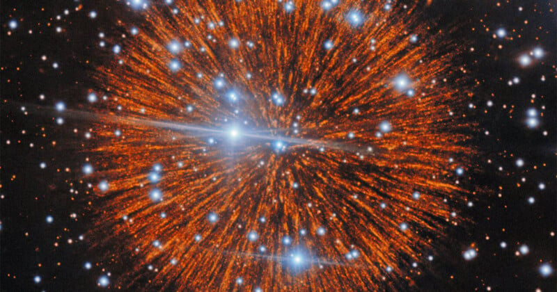 A vibrant, orange-hued nebula radiates outward from a central point, surrounded by numerous bright, blue-tinted stars.