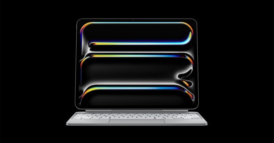 A tablet computer with a metallic keyboard base displays an abstract graphic of three glowing, colorful horizontal lines against a black background.
