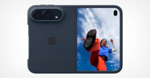 A dark blue, foldable smartphone shown from the back, featuring a dual-camera module and a vertical screen displaying a person kicking toward the camera against a blue sky.