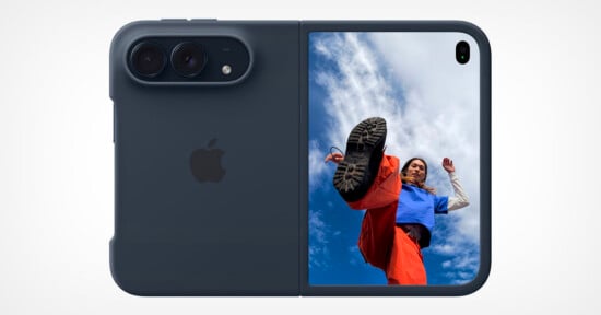 A dark blue, foldable smartphone shown from the back, featuring a dual-camera module and a vertical screen displaying a person kicking toward the camera against a blue sky.