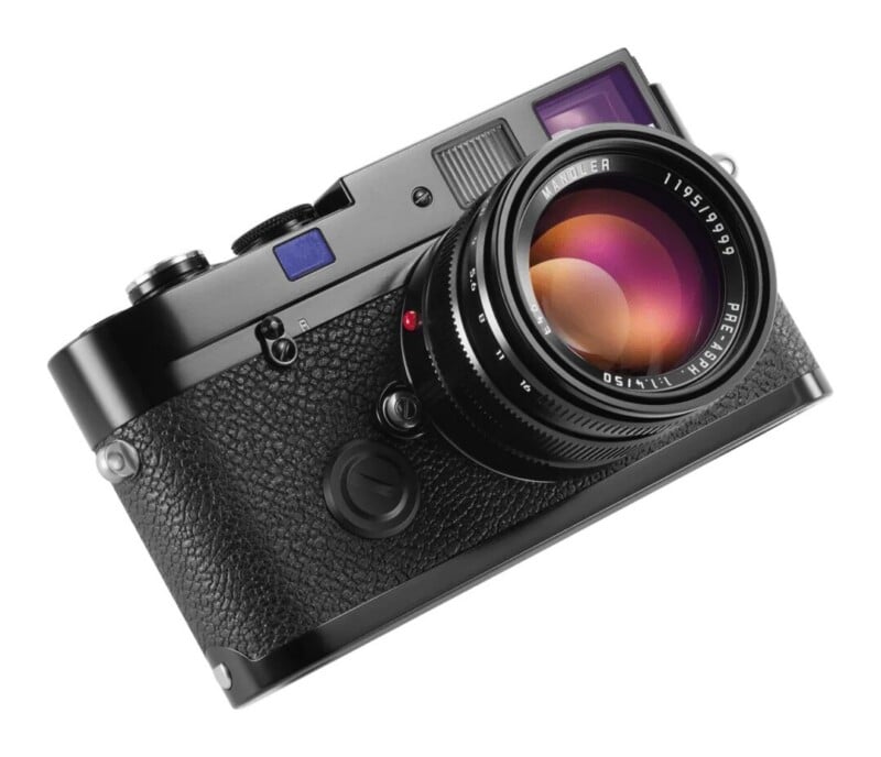 A black rangefinder camera with a lens attached, viewed from a high angle against a white background.