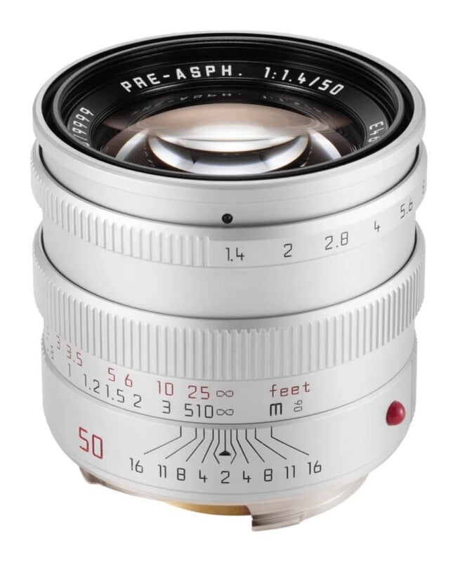A silver Leica 50mm f/1.4 camera lens shown from a front-facing angle against a white background.