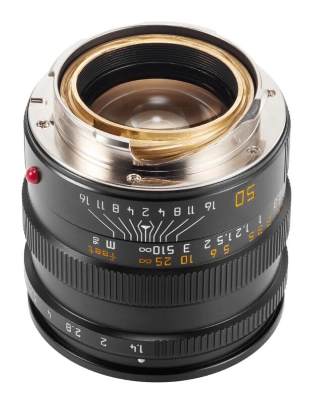 A black camera lens viewed from the rear, showing the brass-colored mount, depth of field scale, and aperture ring marked from 1.4 to 16.