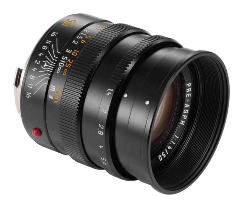 A black Leica 50mm f/1.4 Pre-ASPH camera lens viewed from a side angle, showing the focus and aperture rings with white markings.