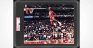 A PSA-authenticated, autographed photograph of Michael Jordan performing a slam dunk during a game, encased in a protective slab.