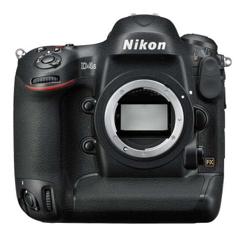 A front view of a black Nikon D4s DSLR camera body with the lens detached, showing the lens mount and mirror.