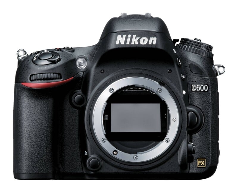 A front view of a black Nikon D600 DSLR camera body with the lens removed, showing the mirror and lens mount.