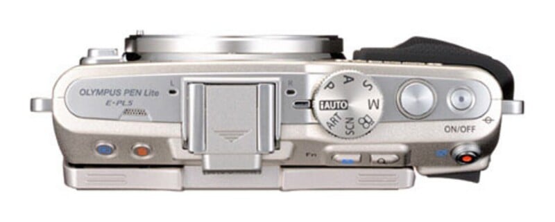 Top-down view of a silver Olympus PEN Lite E-PL5 camera body showing the mode dial, shutter button, and various control buttons.
