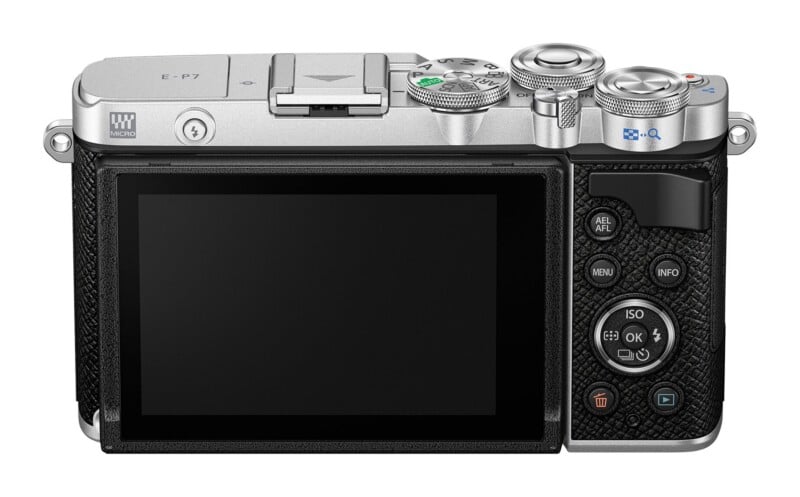 The back of a silver and black digital camera featuring a large LCD screen, a mode dial, various control buttons, and a directional pad.