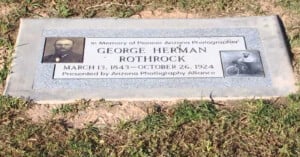 A flat, gray granite grave marker for George Herman Rothrock (1843–1924), a pioneer Arizona photographer, featuring his portrait and a photo of him with a bicycle.