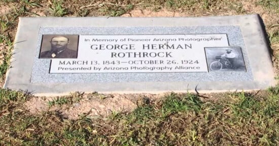 A flat, gray granite grave marker for George Herman Rothrock (1843–1924), a pioneer Arizona photographer, featuring his portrait and a photo of him with a bicycle.