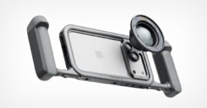 A silver smartphone rig with two side handles and a circular camera lens attachment mounted over the rear camera array.