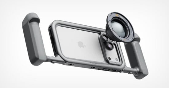 A silver smartphone rig with two side handles and a circular camera lens attachment mounted over the rear camera array.