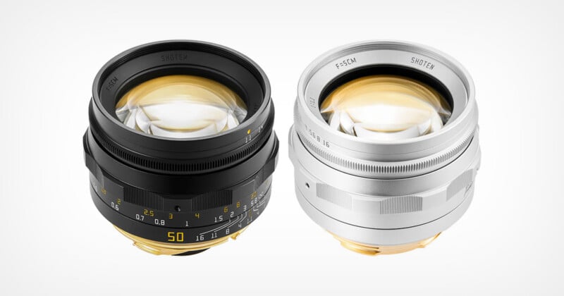 Two manual focus camera lenses, one black and one silver, are positioned side-by-side against a plain white background.