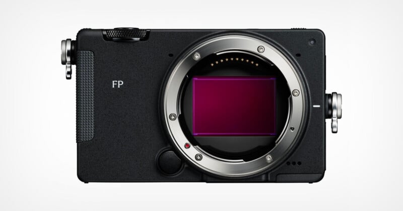 Front view of a black, box-shaped digital camera body with a large circular lens mount and an exposed rectangular sensor, featuring the text "FP" on the front panel.