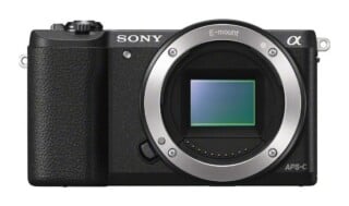 Front view of a black Sony Alpha mirrorless camera body with an E-mount lens opening and an APS-C sensor visible.