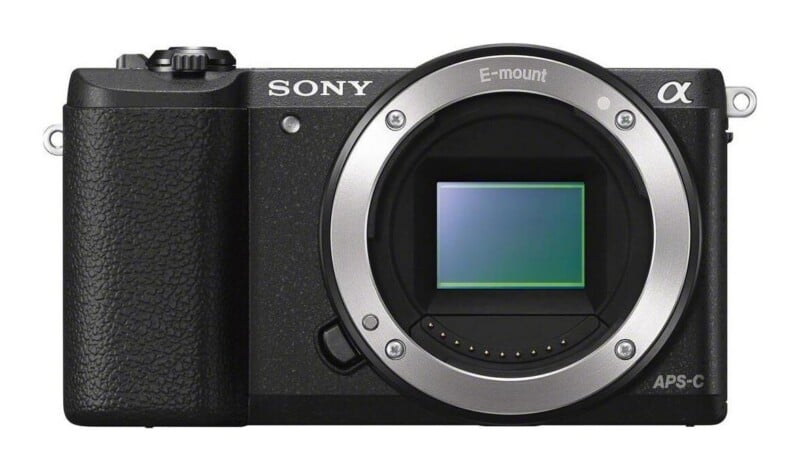 Front view of a black Sony Alpha mirrorless camera body with an E-mount lens opening and an APS-C sensor visible.