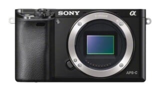 A black Sony Alpha mirrorless camera body with an E-mount lens opening and an APS-C sensor visible on the front.