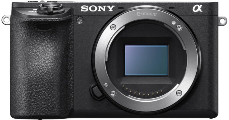A front view of a black mirrorless camera body with an E-mount lens opening and a visible rectangular sensor.