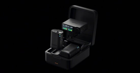 A Sony wireless microphone system with two transmitters and a receiver inside an open black charging case against a black background.
