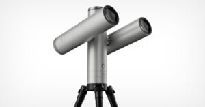 A silver, dual-lens telescope mounted on a black tripod against a white background, with the word "vaonis" printed on the central pillar.